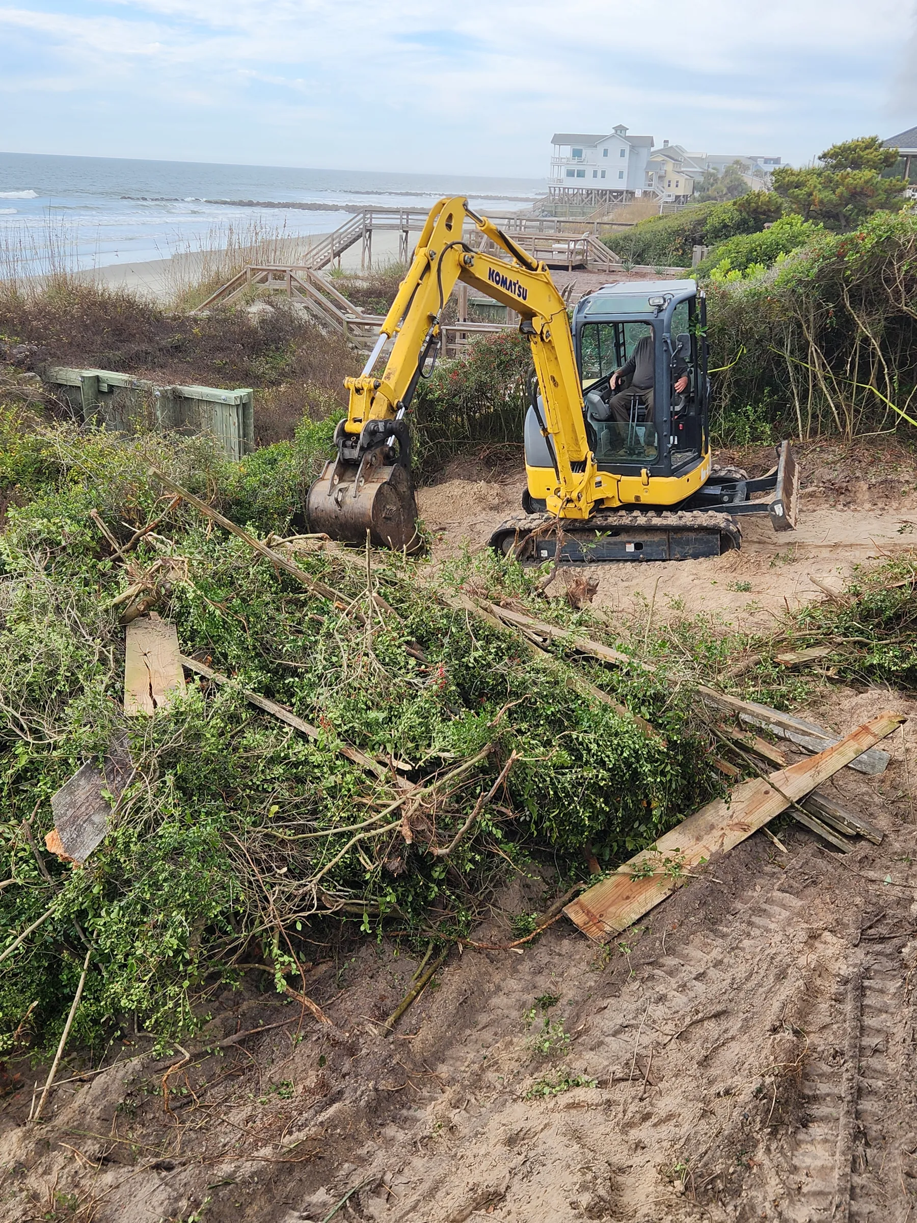 Excavator clearing overgrowth and debris on a Lowcountry lot